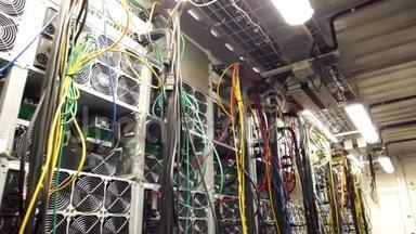 数据中心和电线的墙。 库存录像。 房间内有大量的数据中心风扇和悬挂电缆。 房间：